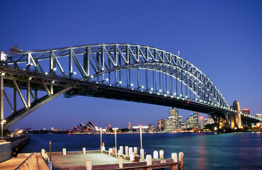 Sydney Harbour Bridge in the foreground and city buildings and Opera House in the background