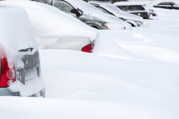 cars buried in snowdrift after heavy snowfall. snow covered cars. winter weather.