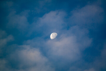 Beautiful white crescent moon in cloudy morning blue sky like a planet