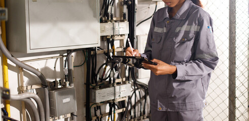 Asian 20s woman in grey uniform as electric fix repair guy. Engineer check inspect wifi signal