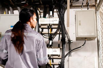 Asian 20s woman in grey uniform as electric fix repair guy. Engineer check inspect wifi signal
