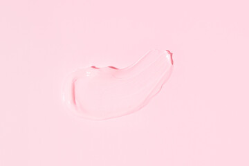 On pink background smeared transparent serum