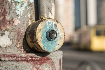 Old dirty shabby button for switching traffic lights at a pedestrian crossing in the city, close up.