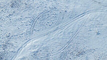 Road and footprints in the snow in the field