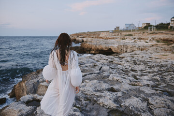 woman by the ocean rocks travel freedom