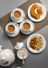 Obraz na płótnie Canvas Tea time with Biscuits and dry fruits, White Plan Cashew, and Almonds. seave in the white marble Tea set. 