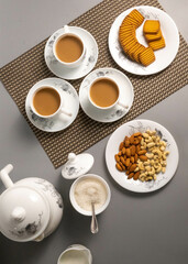 Obraz na płótnie Canvas Tea time with Biscuits and dry fruits, White Plan Cashew, and Almonds. seave in the white marble Tea set. 
