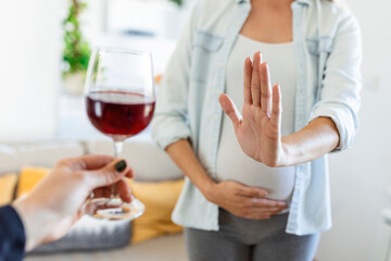 Pregnant woman refusing a glass of wine. Alcohol In Pregnancy. Unrecognizable Expectant Lady...