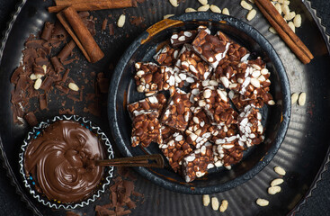 Pieces of chocolate with puffed rice on a dark table