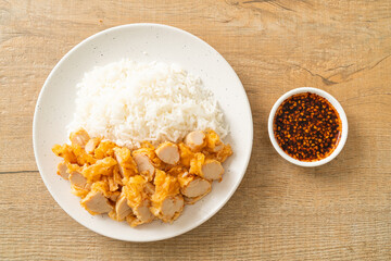 fried chicken topped rice with dipping sauce