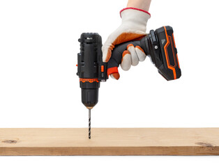 Worker drilling wooden plank by accumulator drill. Isolated on white.