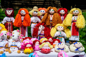 Group of colourful textile traditional hand made decorations, dolls and  toys for children, available for sale at a traditional weekend market in a village near Bucharest, Romania.