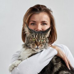 Adult woman hold and hug furry Maine Coon cat