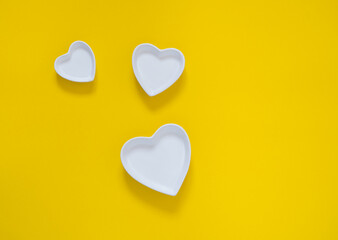 three white hearts on a yellow  background