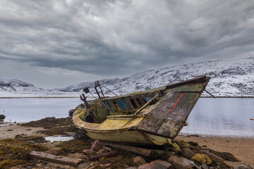 Fototapeta na wymiar An old broken fishing boat. Teriberka village, Murmansk region, Russia.