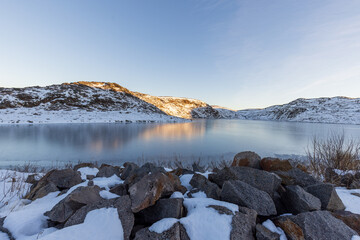 Estuary of the Arctic Ocean on a catwalk with stone snow in the foreground. Teriberka village, Murmansk region, Russia.