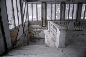 An ancient staircase in an old abandoned manor. Dirty shabby steps. Beautiful architecture.