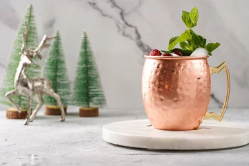 Badezimmer Foto Rückwand Traditional american alcoholic beverage moscow mule in copper mugs with cranberry and mint on white marble board - non-alcoholic cocktail version with christmas decoration © Romana