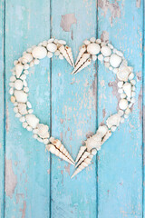 Heart shaped seashell wreath with white shell collection. Romantic concept symbol for Valentines Day or summer vacation greetings card.