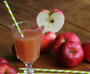 Fresh apple juice in glass with red apple on rustic wooden table .Selective Focus,