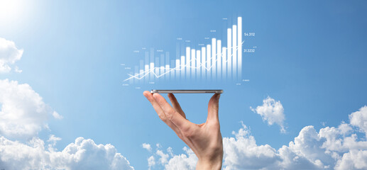 Business man holding tablet and showing holographic graphs and stock market statistics gain profits. Concept of growth planning and business strategy. Display of good economy form digital screen.