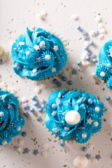 Sweet cupcakes made of sprinkles and blue cream.