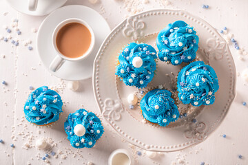 Unique blue cupcakes served with coffee in white porcelain.