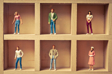 boxed figurines of various people, pigeonhole and social distancing concept