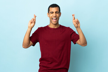 Fototapeta premium African American man over isolated background with fingers crossing