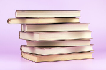 Stack of books on pink background. Study, education and back to school concept.