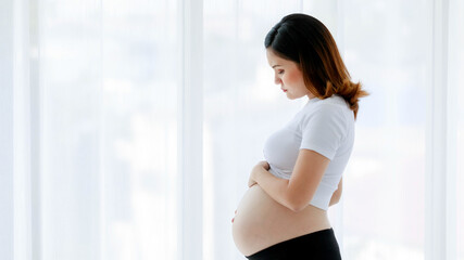 Asian young stressed depressed upset sick unhappy female pregnancy mother standing alone thinking...