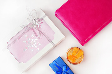 Gift boxes and a pink cover book on a white background