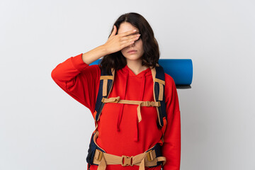 Teenager mountaineer girl with a big backpack isolated on white background covering eyes by hands. Do not want to see something