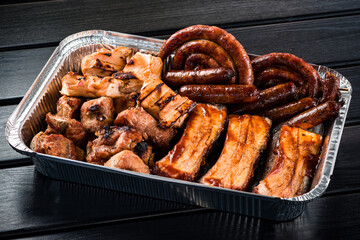 set of grilled ribs and BBQ meat in a delivery box