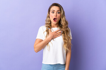 Young Brazilian woman isolated on purple background surprised and shocked while looking right