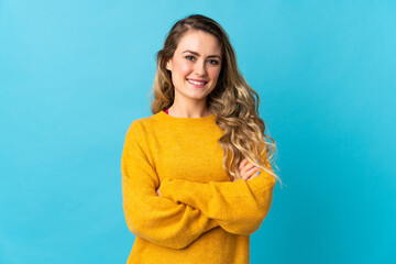 Young Brazilian woman isolated on blue background keeping the arms crossed in frontal position