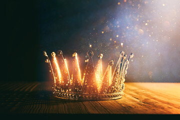 low key image of beautiful queen/king crown over wooden table. vintage filtered. fantasy medieval...
