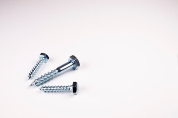Three screws on a white background. Large screw and two small screws