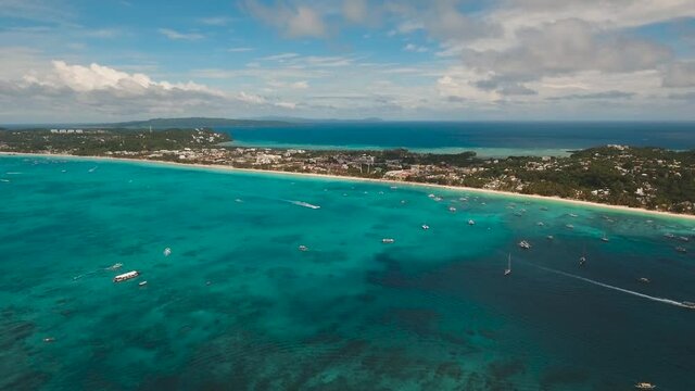 Aerial footage sand beach and palm trees on tropical island with turquoise sea. Coast with hotels and villas on island Boracay.