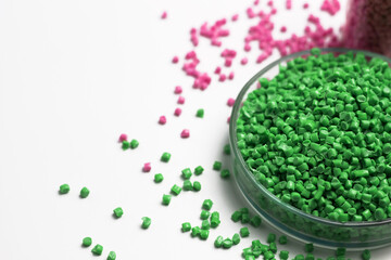 Green  granules of polypropylene or polyamide on a white background. Plastics and polymers...