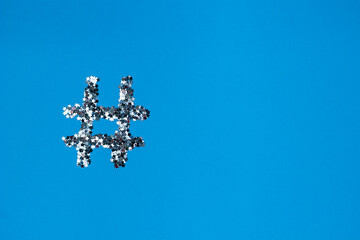 Silver shiny hashtag on a light blue background. Online technology concept and social media...