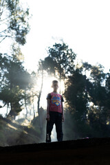 silhouette of a young boy and sun rays in the background