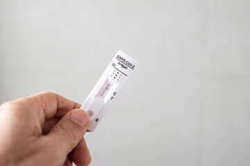 hand holding an antigen test for coronavirus or SARS CoV2 or covid, with negative result, selective focus in the test, copy space, on a white background - obrazy, fototapety, plakaty