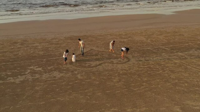 family, leisure and people concept-aerial view of big asian happy family drawing heart on tropical beach
