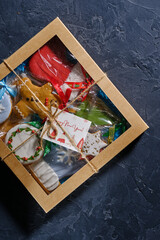 Christmas gift with gingerbread on blue background with fir branches, bumps and decor