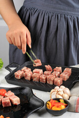 Female Chef Preparing Premium Wagyu Diced Beef or Saikoro, Marble Meat Cut into Cubed for Grill, Tepanyaki, or Yakiniku. Selected Focus