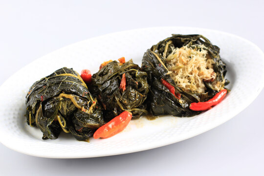 Buntil is Traditional Indonesian Food Made from Papaya/Cassava Leaves Stuffed with Grated Coconut, Petai Cina,  and Anchovy Fish. Popular in Javanese and Sundanese Cuisine, Copy Space Isolated