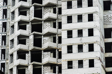 Fragment of a white sand-lime brick apartment building under construction. Close-up