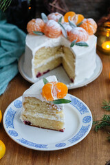christmas cake on a wooden table. pine branches, tangerine and christmas gingerbread cookies. New Year. Rustic. Side view.
