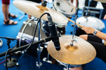 A microphone for amplification and sound recording is installed on a drum kit. Preparation of musical equipment for the concert. Close-up